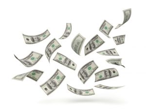 Multiple U.S. dollar bills floating in the air on a white background.
