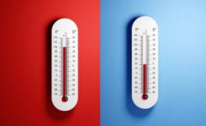 Two thermometers against red and blue backgrounds showing temperature ranges, representing heat pump performance.
