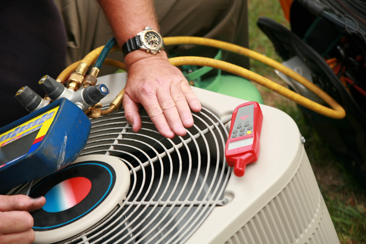 A technician performing a tune-up on an hvac unit